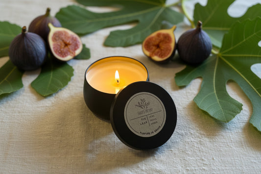 Fig leaf candle in a black container with a label on a textured surface