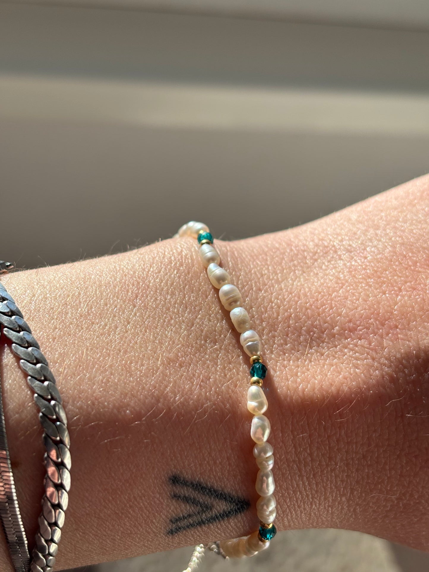 Close-up of a wrist wearing a beaded bracelet with a blurred background