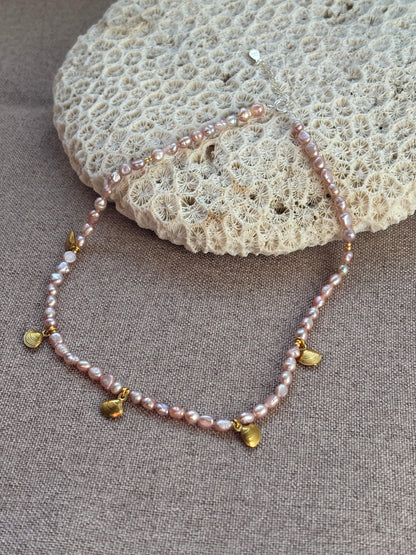 Pearl necklace with gold accents on a textured surface
